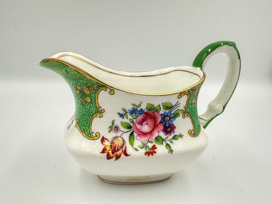 A green, white, and multicolored floral-patterned Aynsley bone china creamer pitcher.