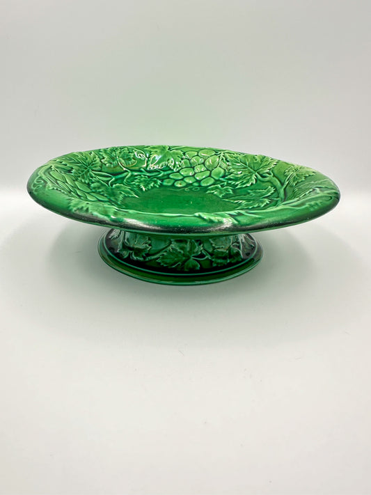 A late 19th century English green majolica footed bowl with a grape vine pattern, unmarked on the bottom.