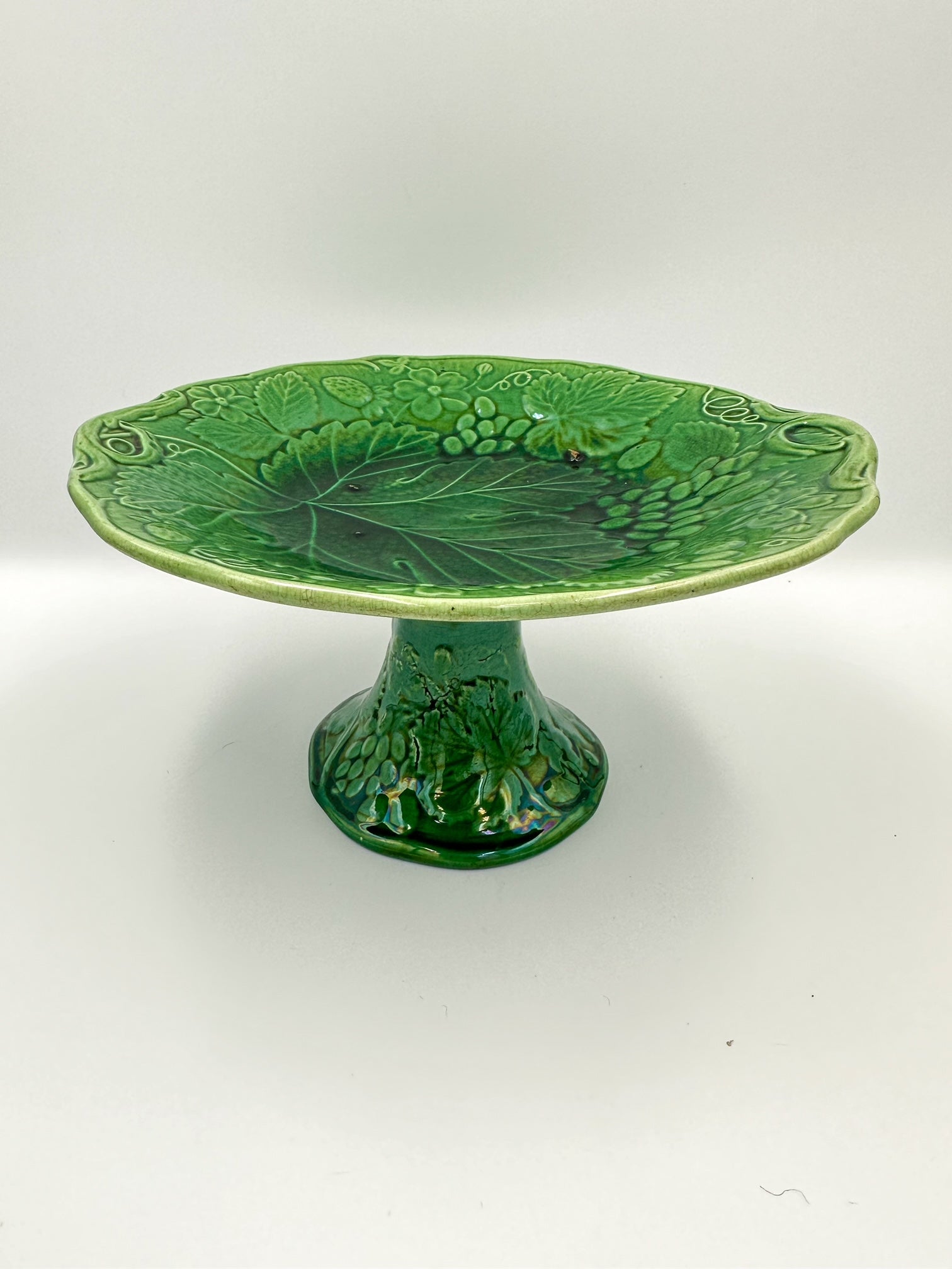 A late 19th century English green majolica footed bowl with a glazed grape vine design, unmarked on the bottom.