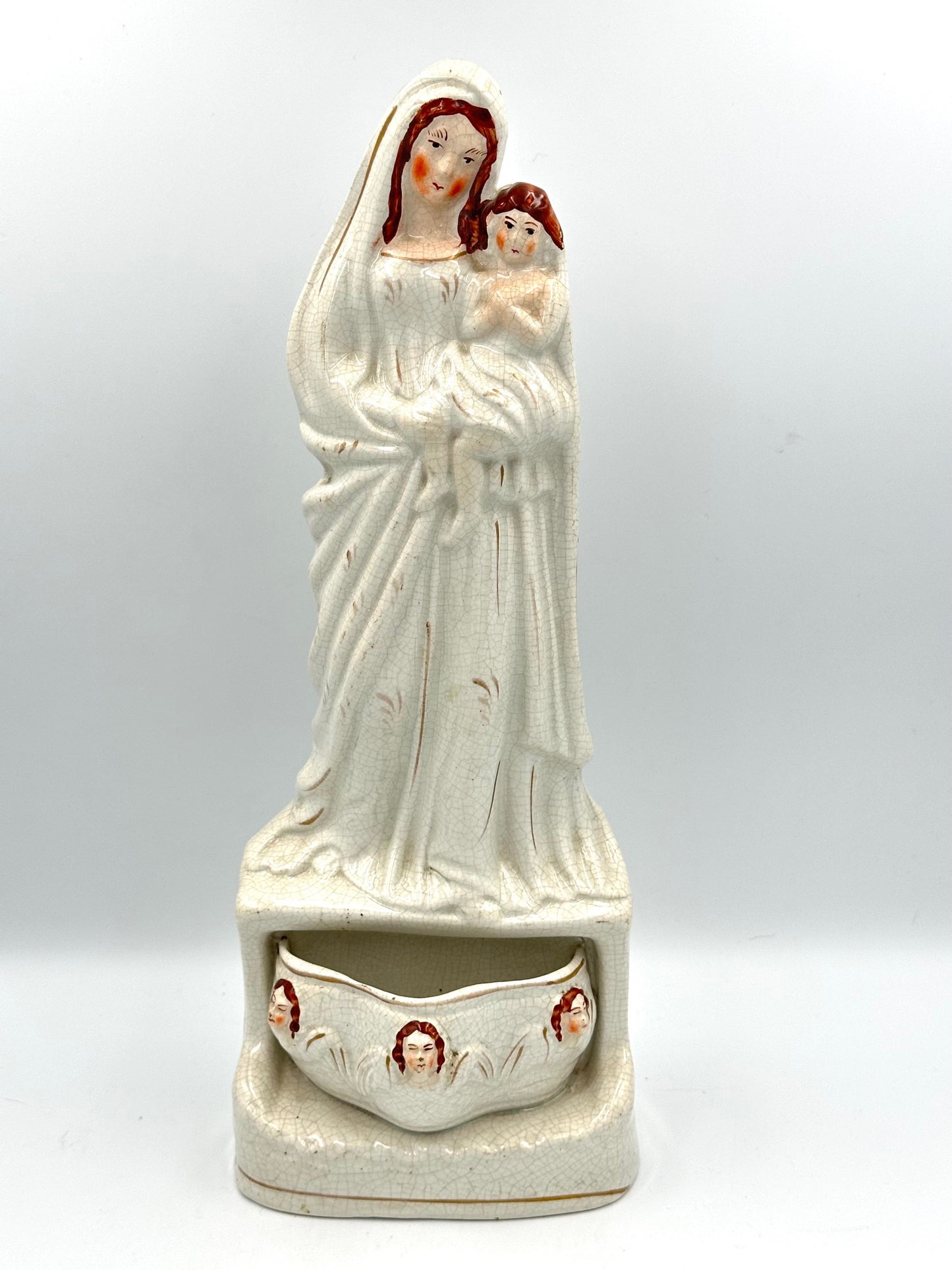 Staffordshire Flatback figurine depicting Jesus, Mary, and the Holy Water stoup, with hand-painted faces, in antique condition.