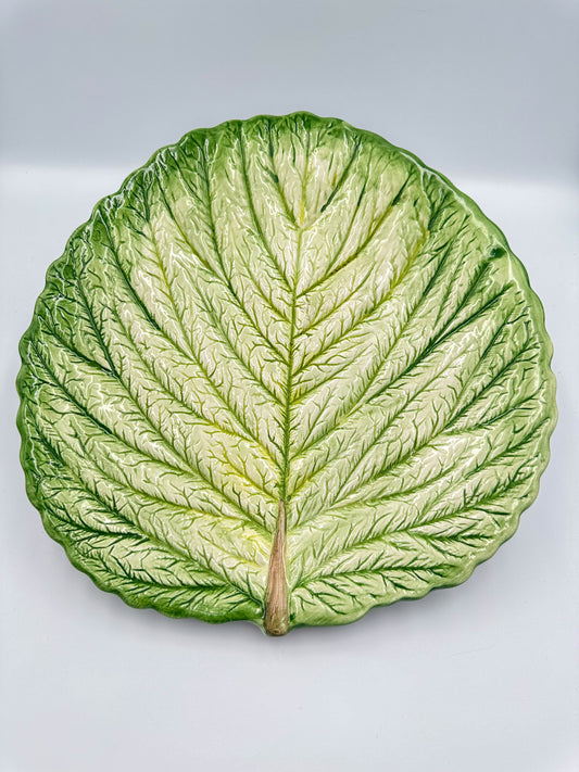 A vintage French cabbage leaf-shaped majolica serving platter with a raised relief stalk and veins, in natural glazed colors.