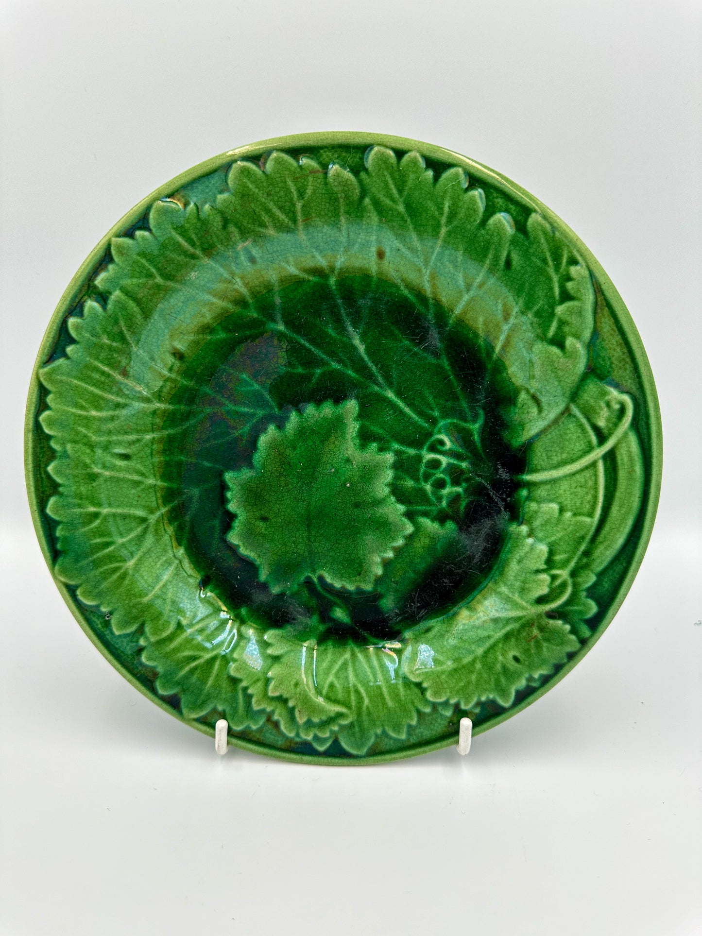 A 19th Century Majolica green vine leaf plate with an iridescent green glaze, featuring a grapevine design.