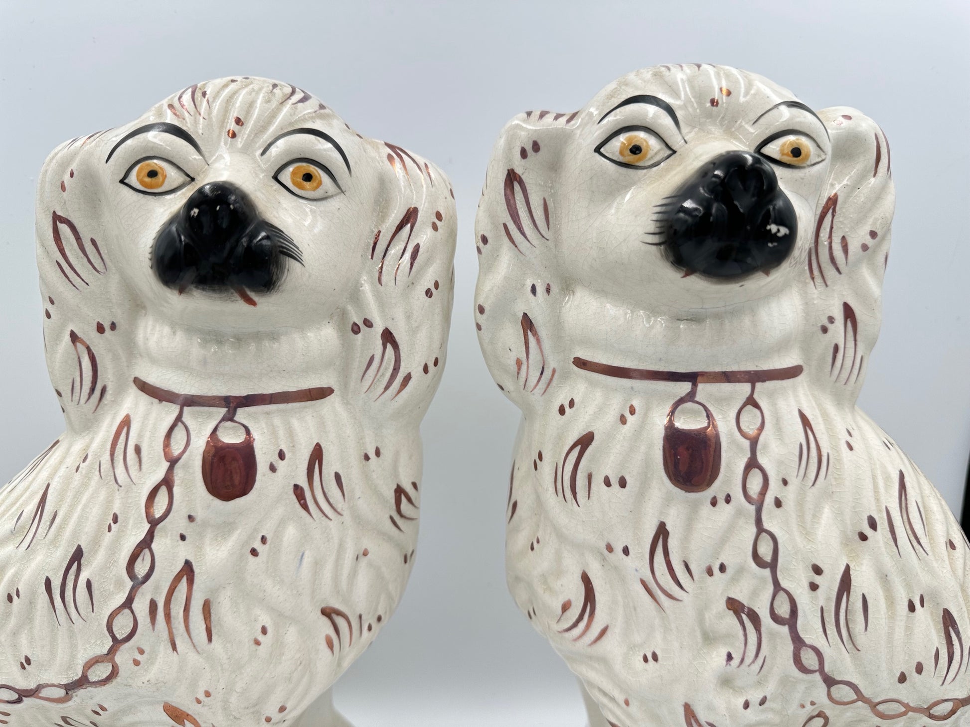 A pair of antique white Staffordshire King Charles Spaniels with pink lustre fan accents.