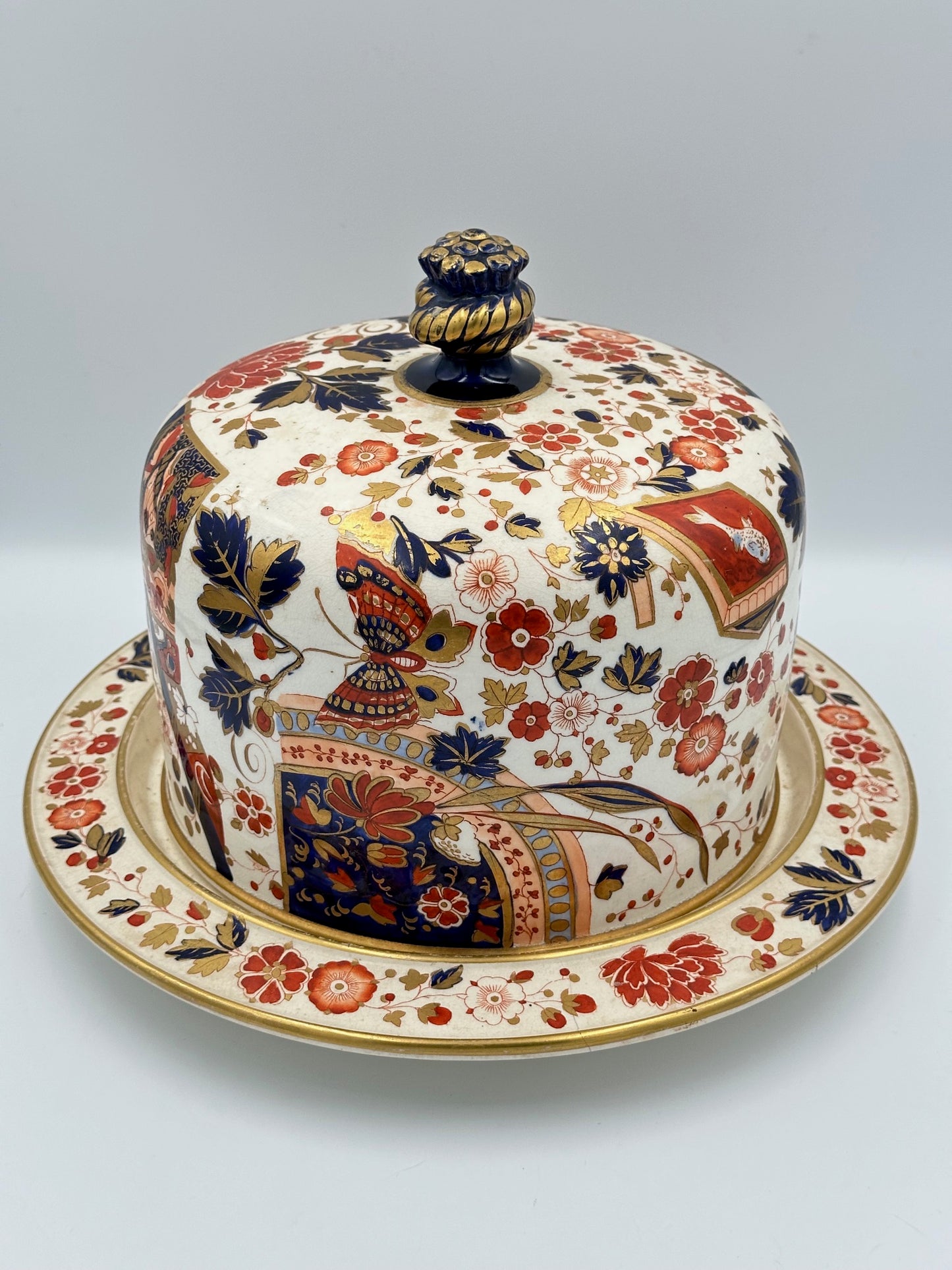 Antique Ridgway Old Derby Imari pattern cheese dome with floral and geometric designs, featuring a domed finial handle and gilding.