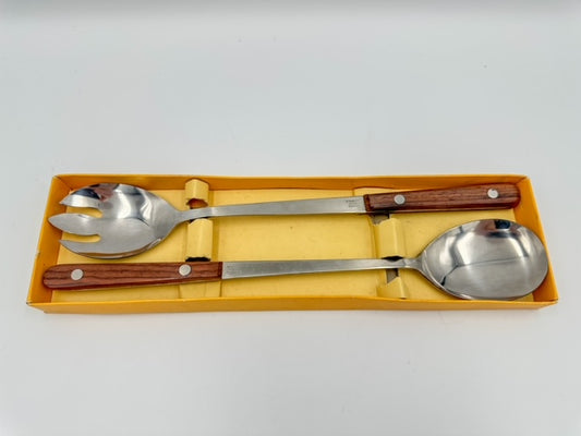 A set of stainless steel salad servers with rosewood handles, displayed in a yellow-colored box.
