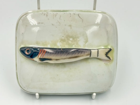 A porcelain lustreware sardine dish with a fish handle on the lid, featuring a simulated fish scale pattern on the sardine.