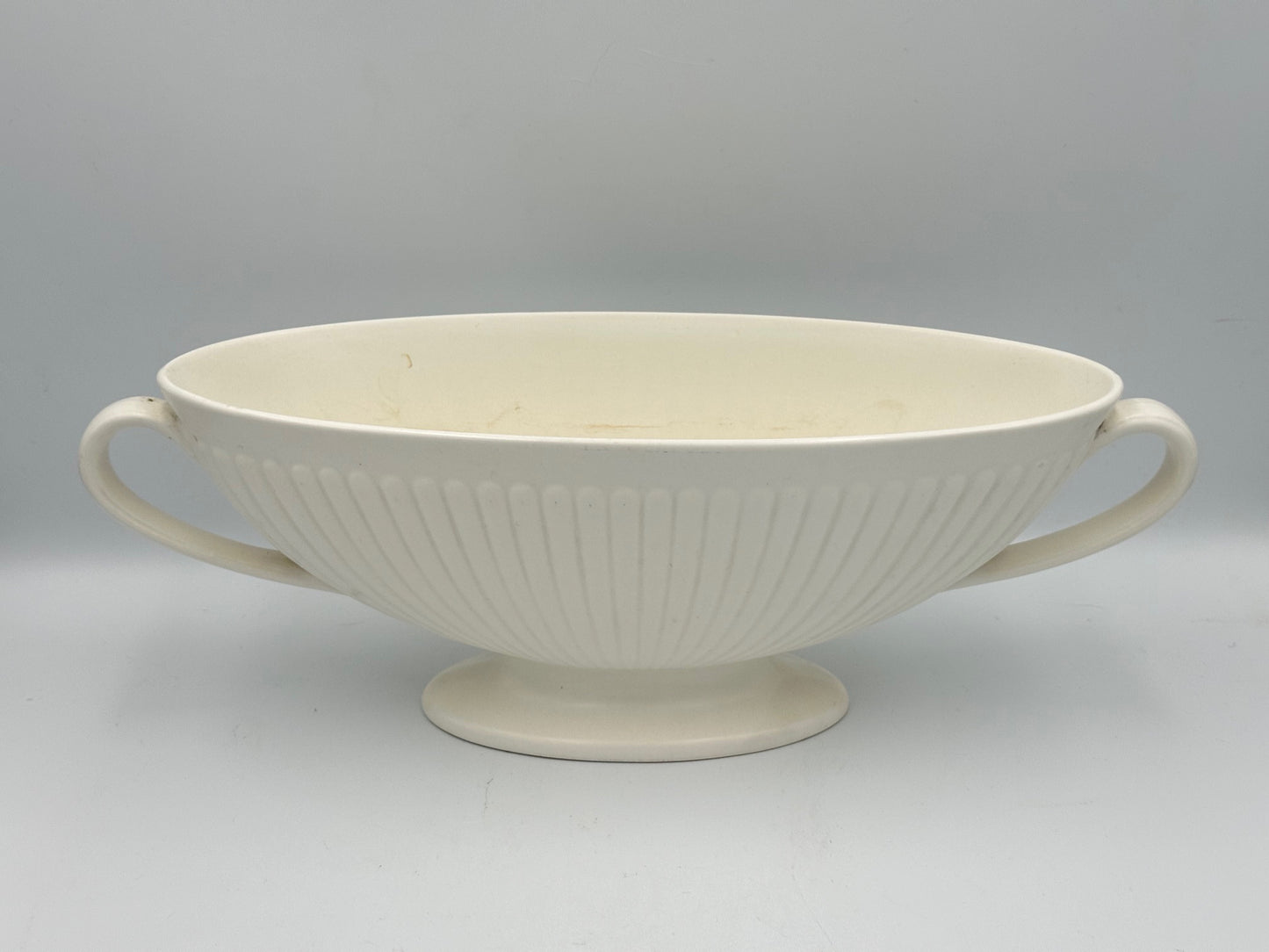 A Wedgwood white moonstone mantle vase with a ribbed and fluted design, featuring a footed base.