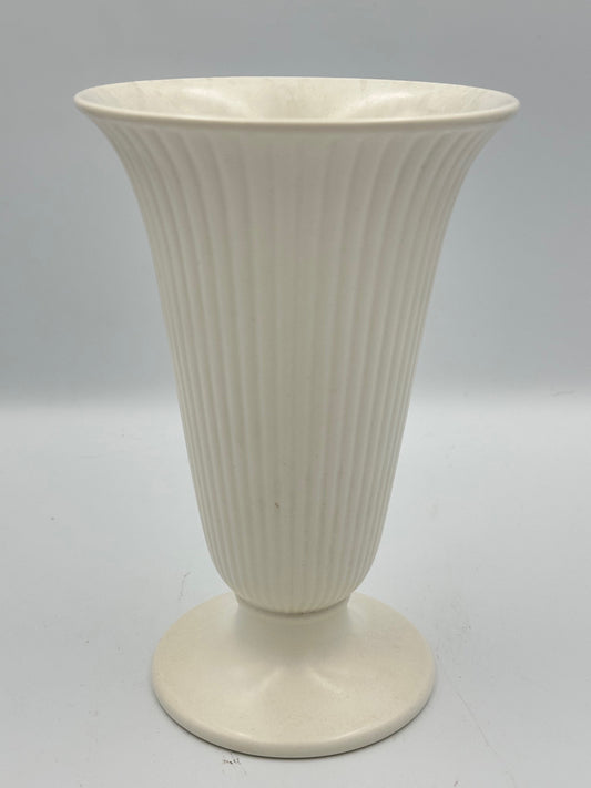 A white, ribbed, fluted trumpet vase with a footed base.