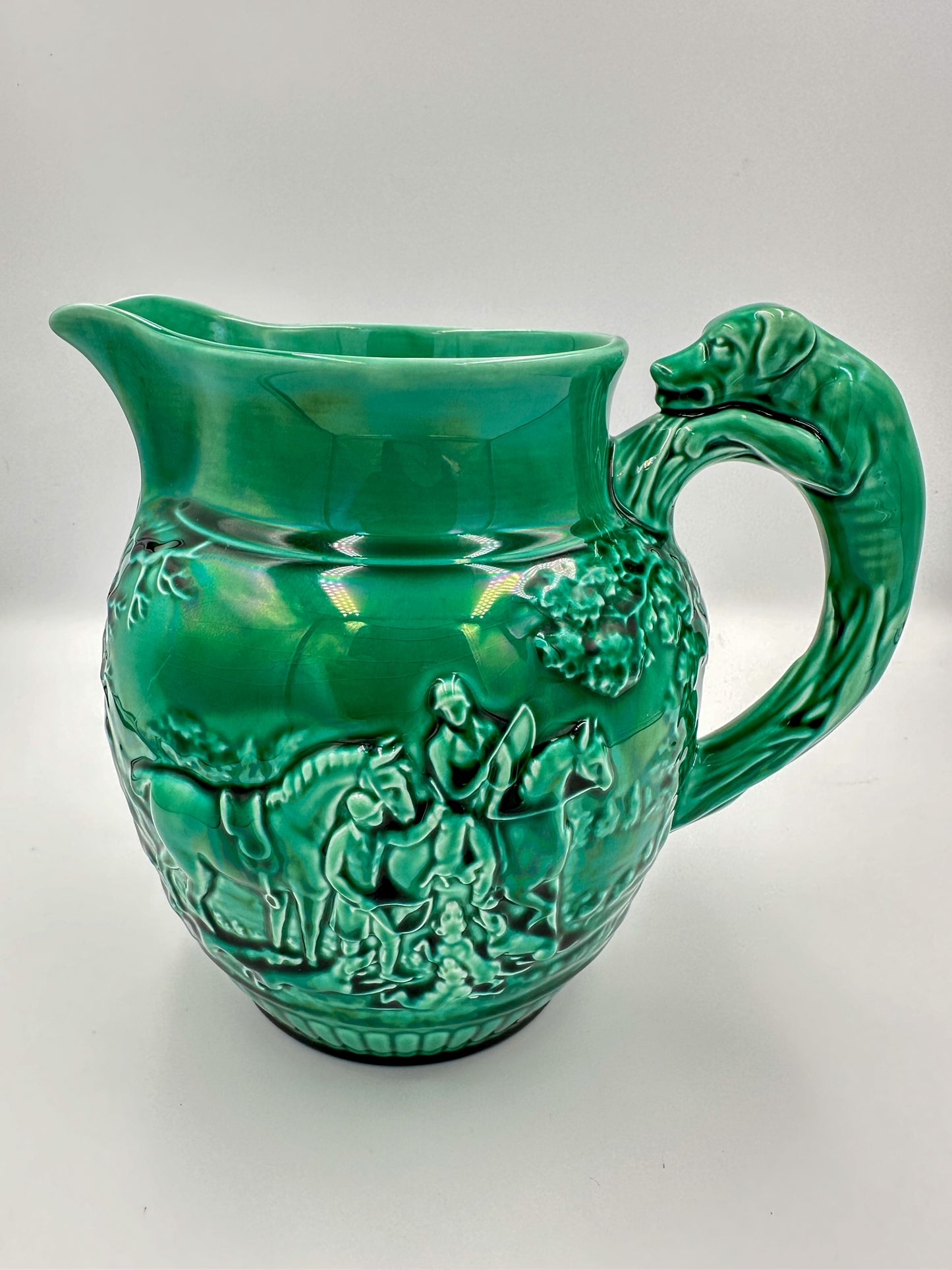 A bright green Wedgwood Majolica large pitcher featuring intricate glaze work with a hunting theme.