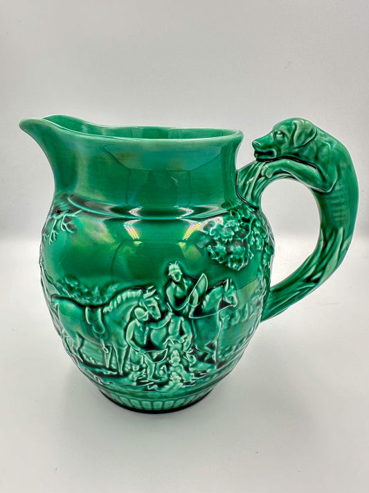 A bright green Wedgwood Majolica large pitcher featuring intricate glaze work with a hunting theme.