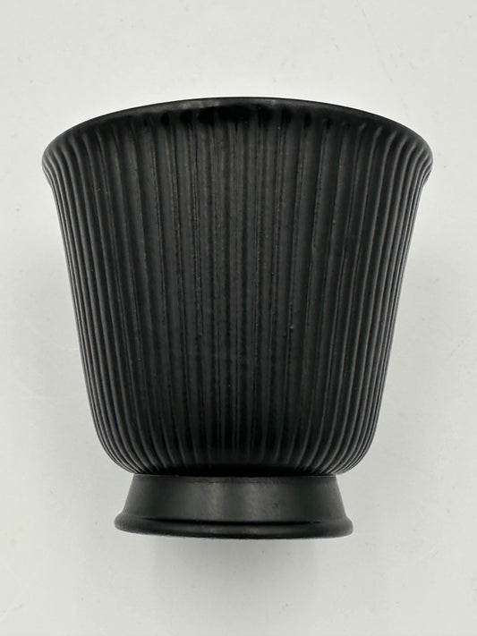 A vintage Wedgwood black Ravenstone small trumpet vase with a ribbed design.