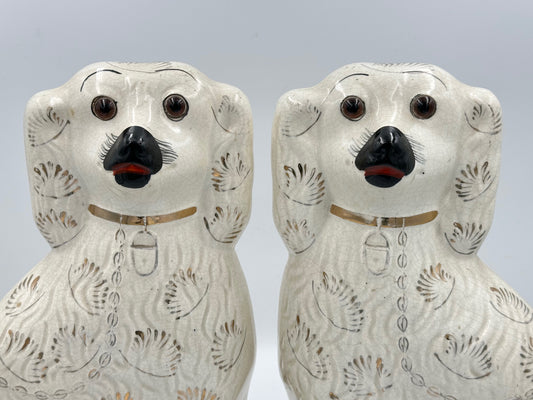 Pair of white staffordshire spaniels with gold fan decorations and glass eyes.